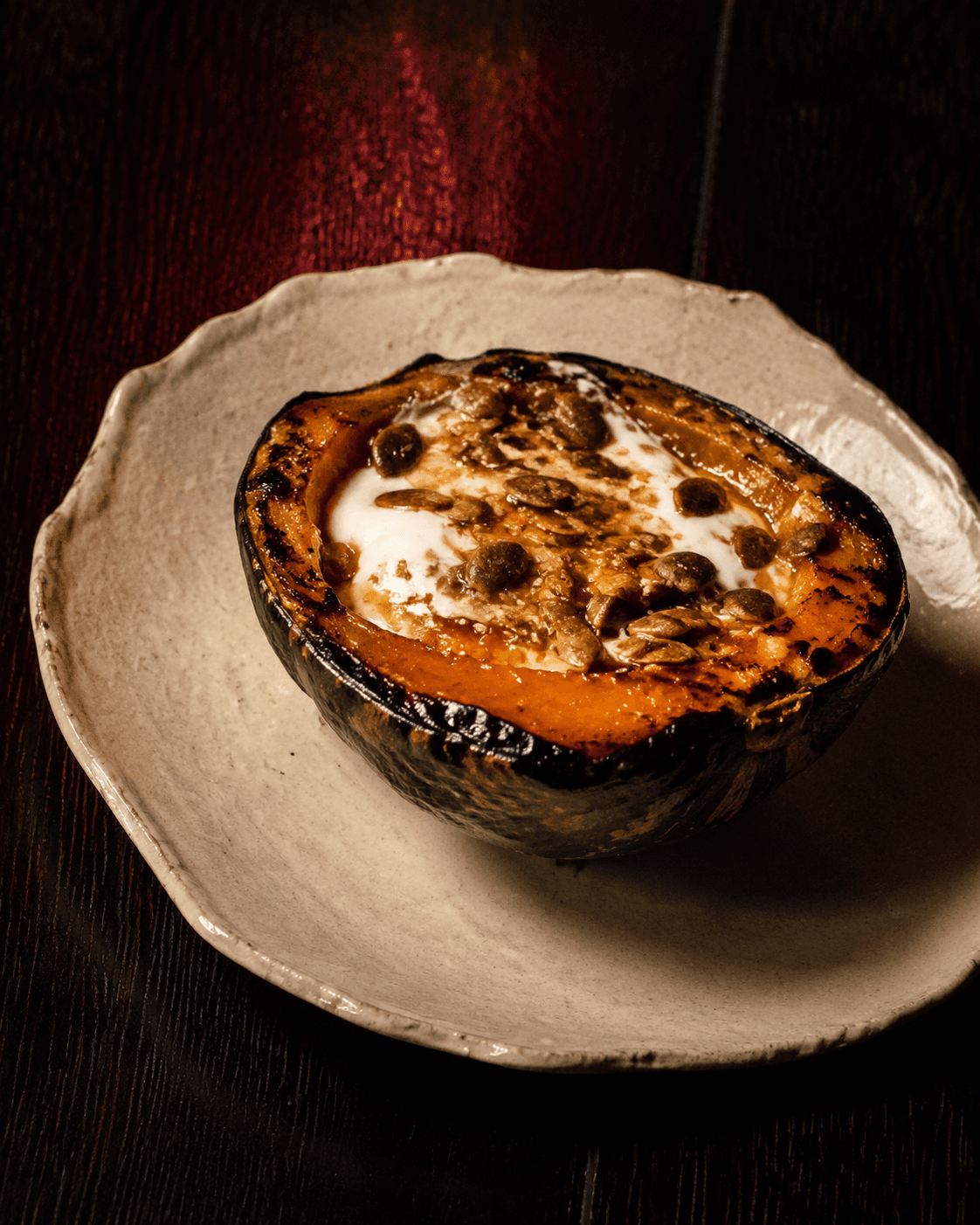 Kabocha glaseada a la brasa, servida entera con glaseado oscuro