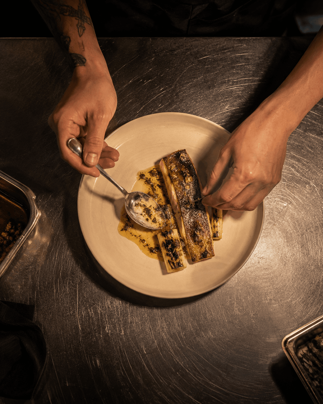 Trucha al fuego recién emplatada con puerro quemado y mantequilla ácida